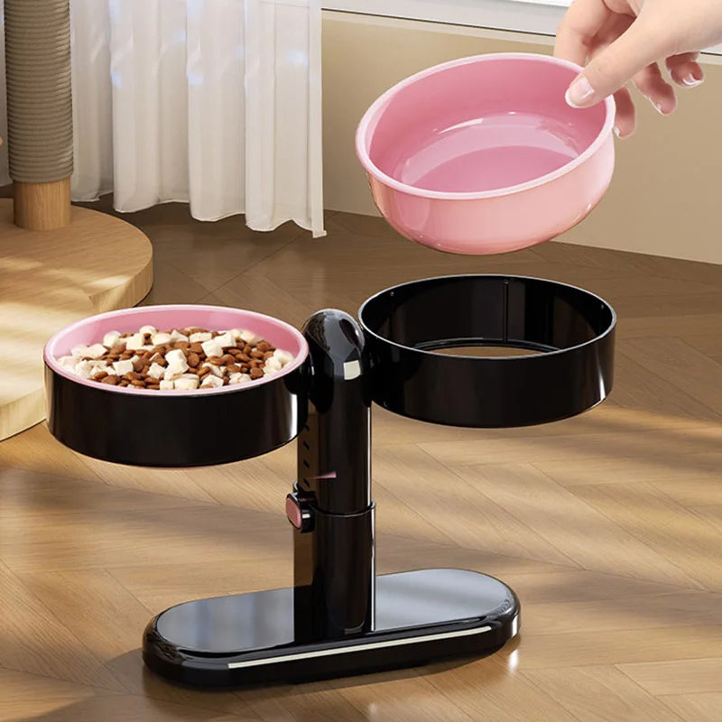 Hand lifting a detachable pink bowl from a black elevated double bowl pet feeder