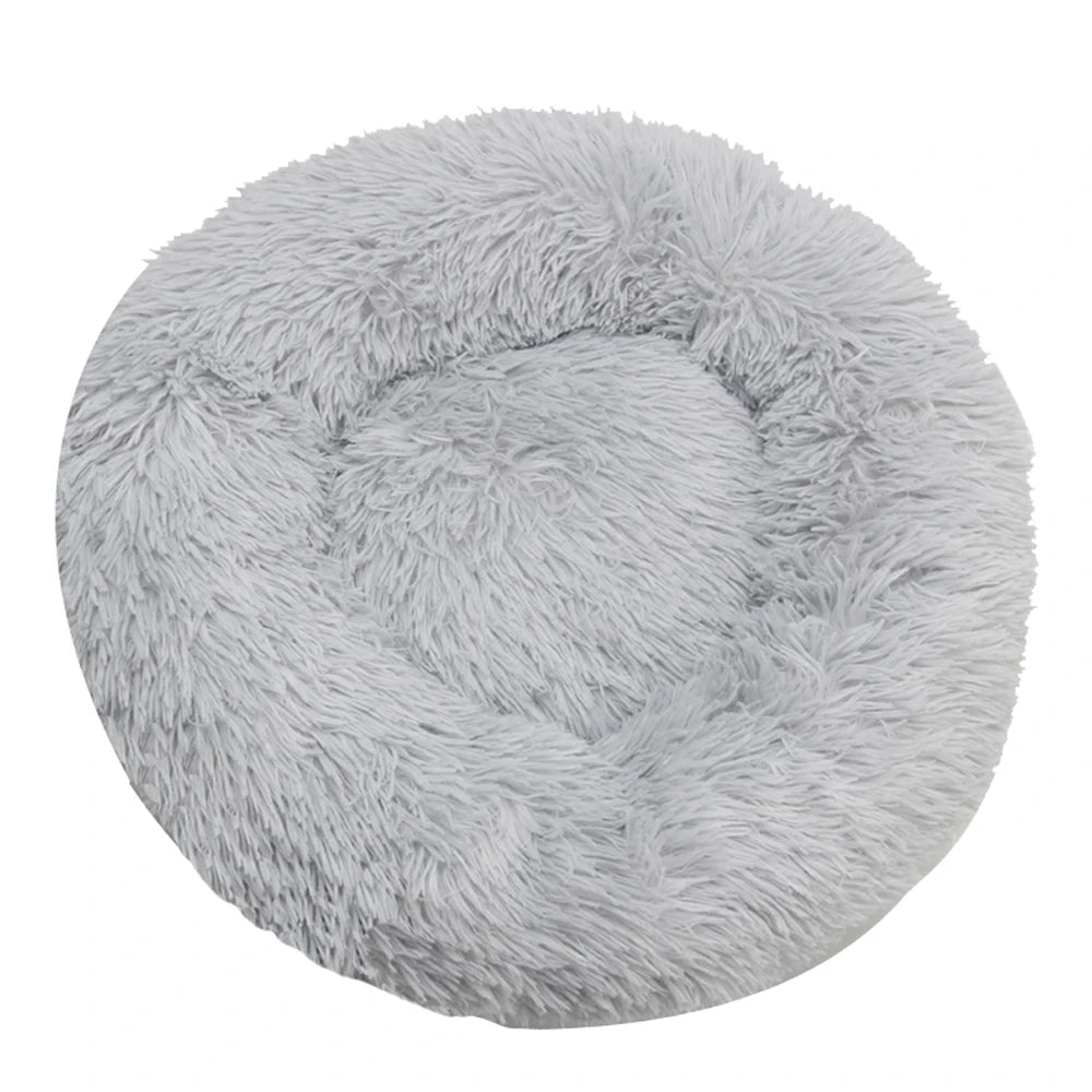 Top-down view of a round plush calming dog bed in light grey faux fur