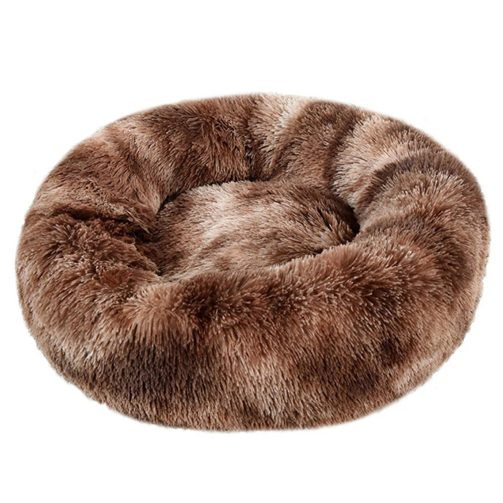 Round plush calming dog bed in brown faux fur on a white background