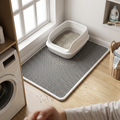 Splash-proof litter mat placed under a litter box in a tidy laundry room